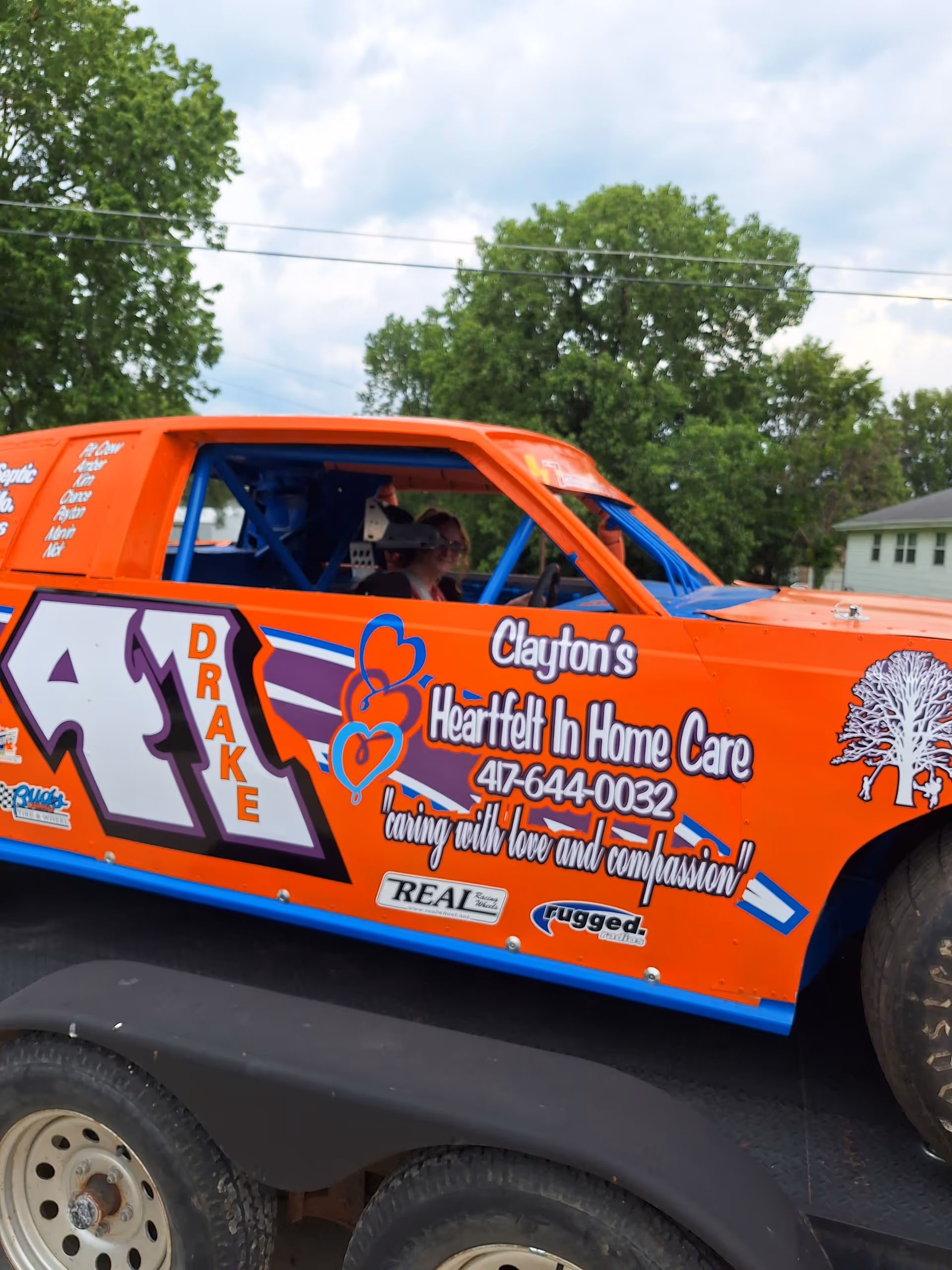 Bright orange branded Clayton's Heartfelt In Home Care van parked outdoors.