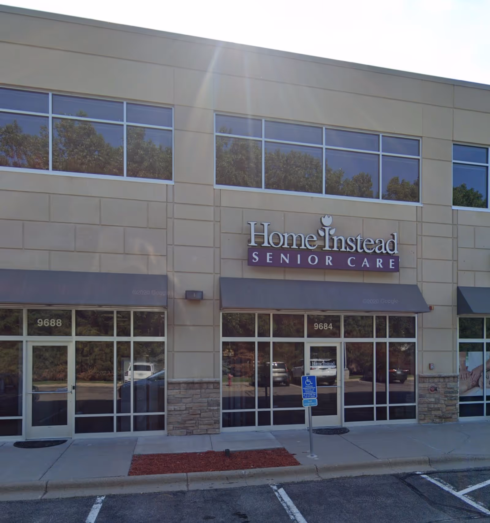 Exterior view of Home Instead Senior Care storefront with large sign.