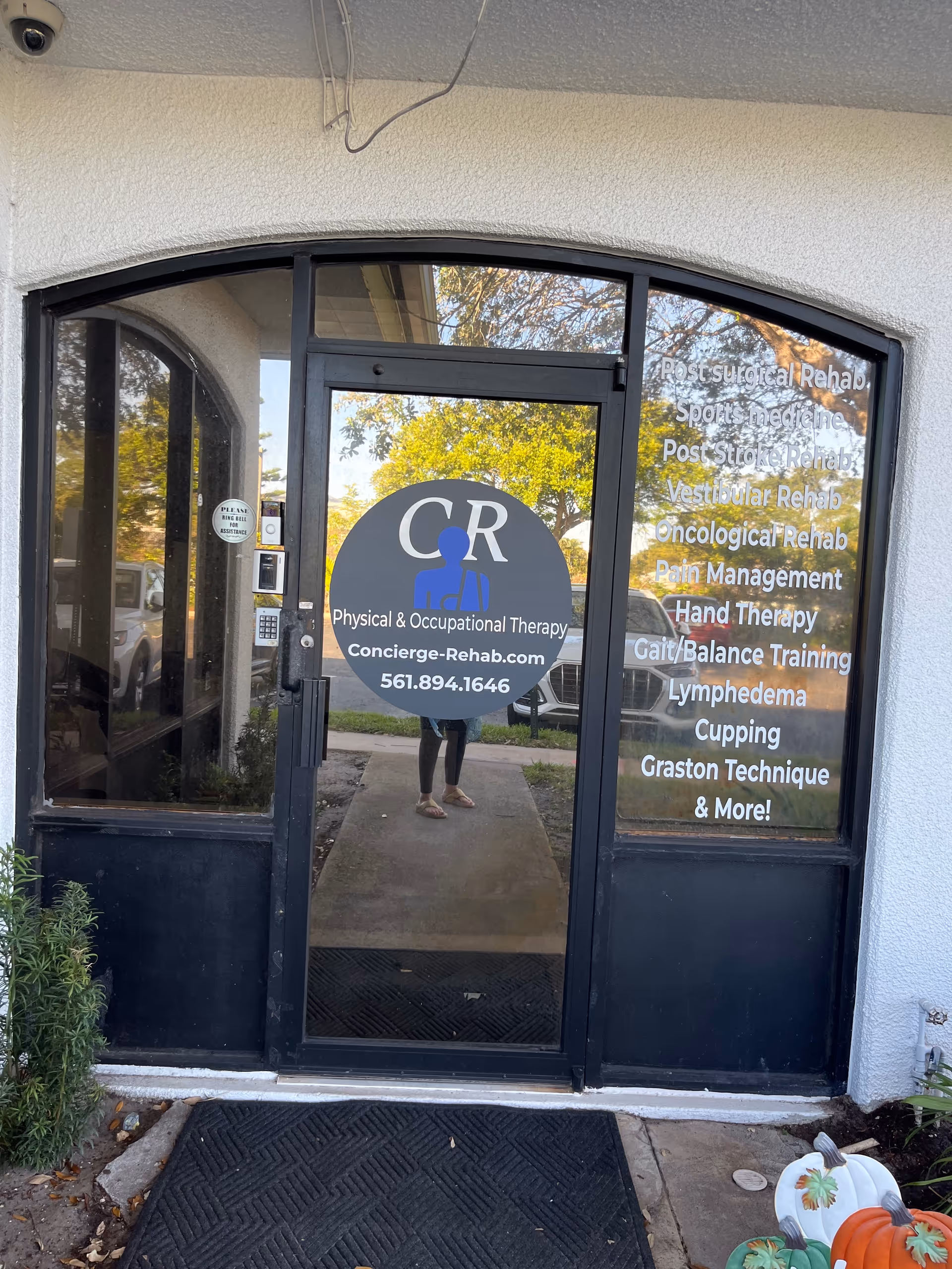Glass entrance door featuring CR logo and service list for Concierge Rehab Physical Therapy.