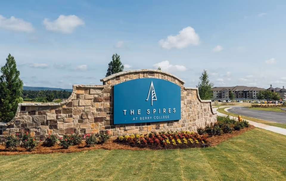 Stone entrance sign reading The Spires at Berry College with landscaped foreground.