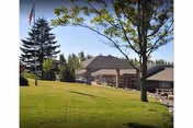 Green lawn, flagpole, trees, and the Life Care Center of Port Townsend front entrance.