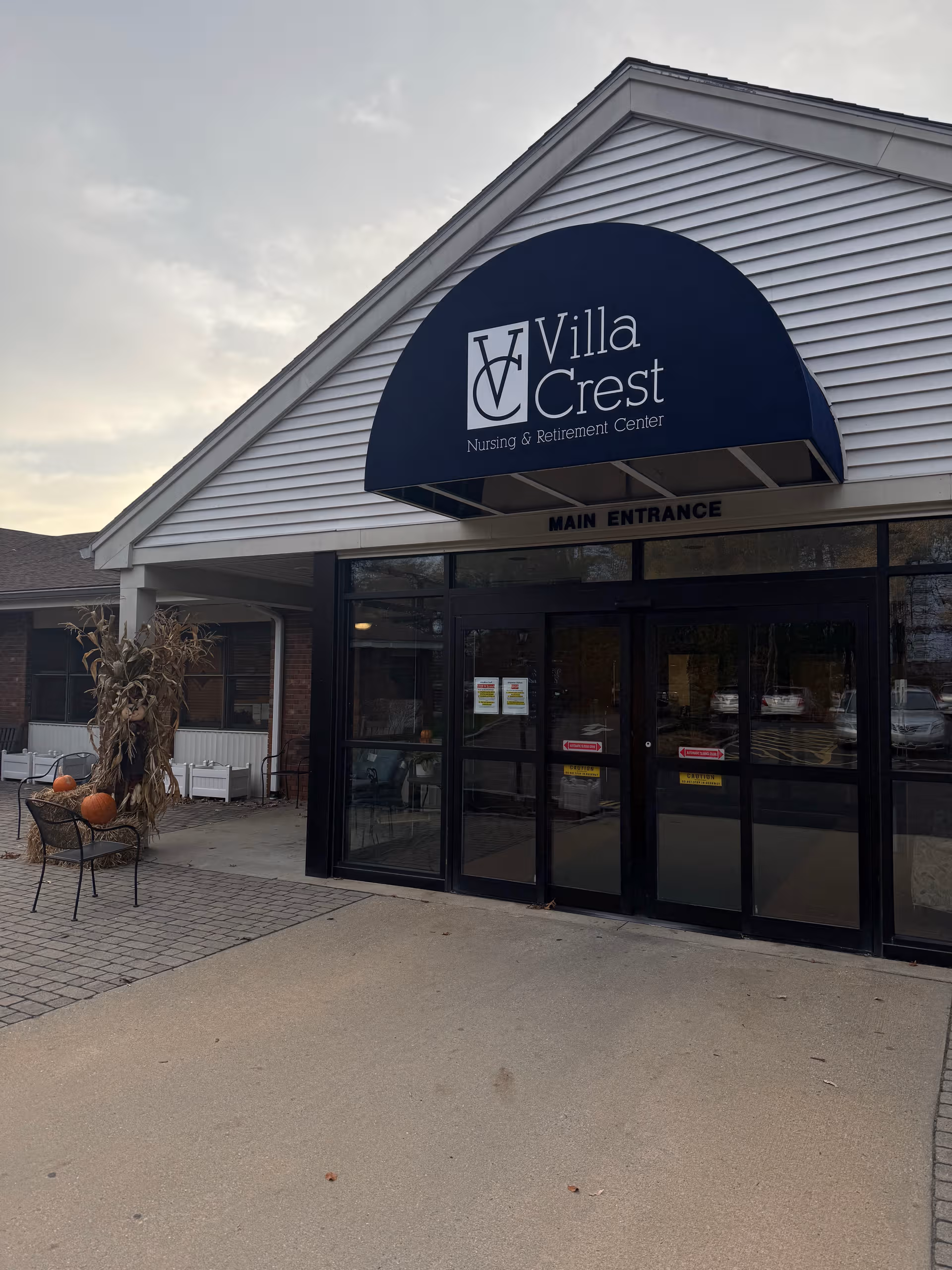 Exterior view of Villa Crest Nursing and Retirement Center main entrance with blue awning.