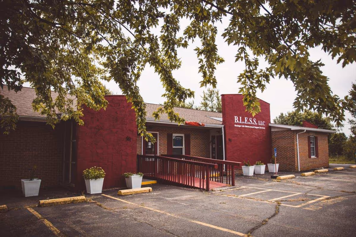 Front view of Bless LLC senior living facility with ramp, planters, and parking.