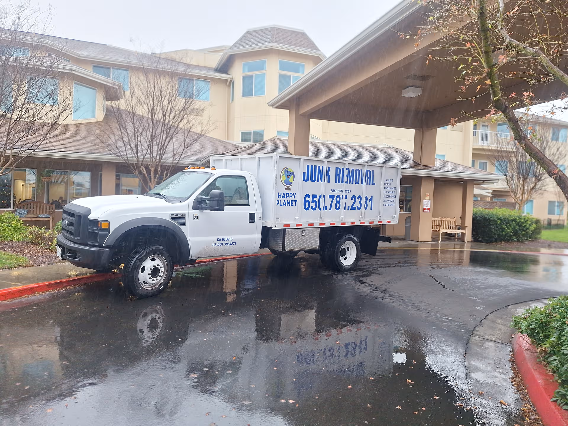 A white junk-removal truck parked in front of Solstice Senior Living at Lodi entrance.