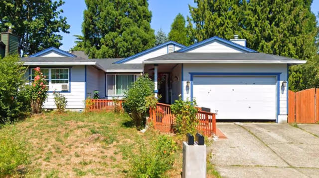 Front exterior of a single-story blue-and-white home with a two-car garage and lawn.
