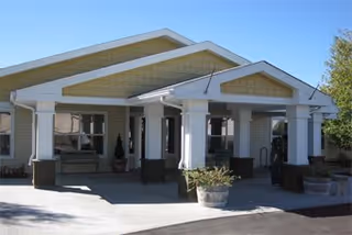 Front entrance of Prairie House Assisted Living and Memory Care with columns and planters.