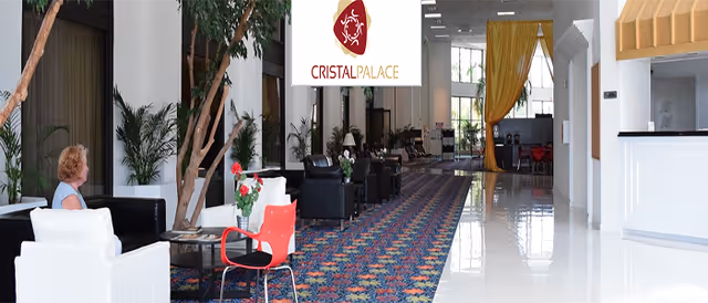 Interior lobby of Cristal Palace Resort with seating, plants, and a reception area.