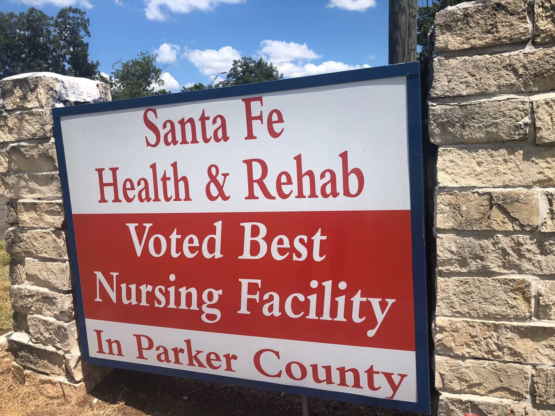 Outdoor sign reads Santa Fe Health and Rehab, Voted Best Nursing Facility, Parker County.