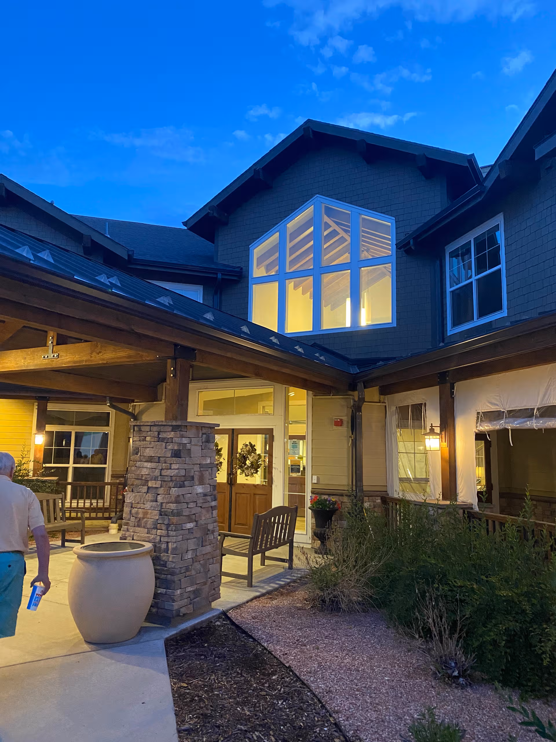 Exterior view of MorningStar of Wheat Ridge entrance with benches and landscaping.