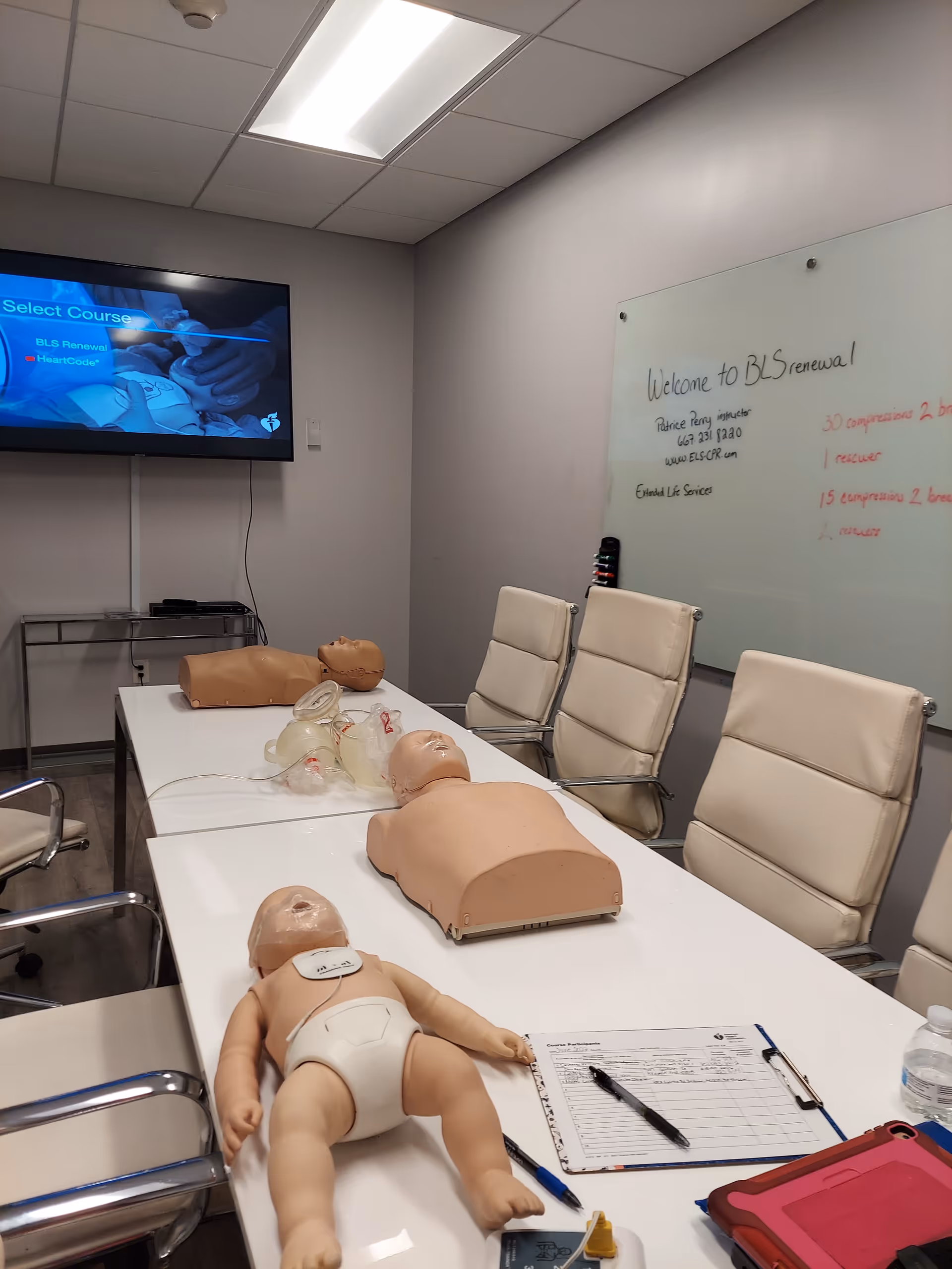 Training room with CPR mannequins, a whiteboard, and a projection screen