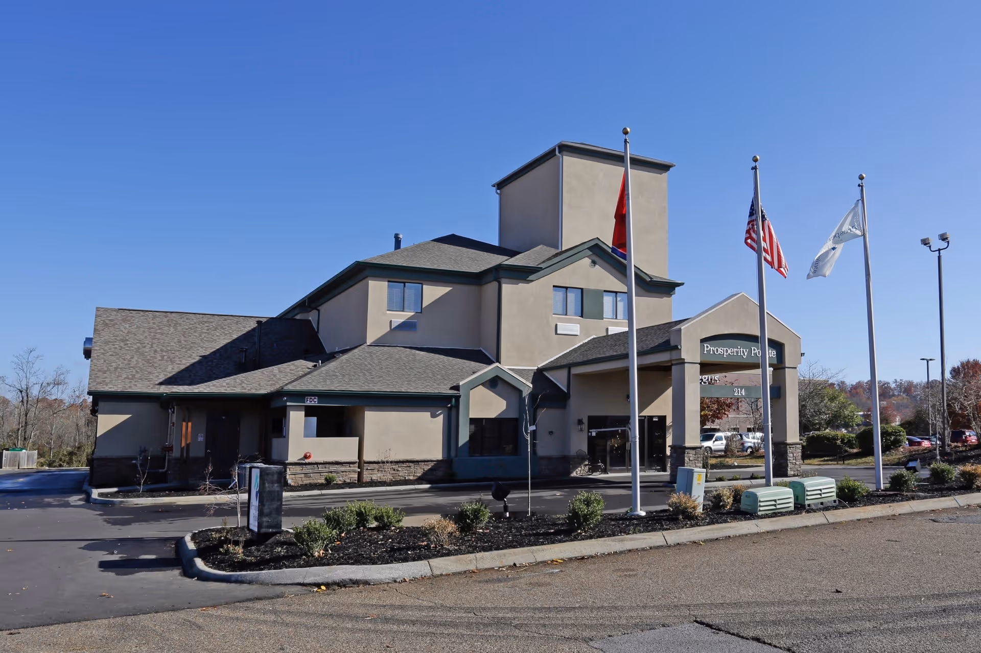 Exterior view of Prosperity Pointe senior living building with front entrance and flagpoles.