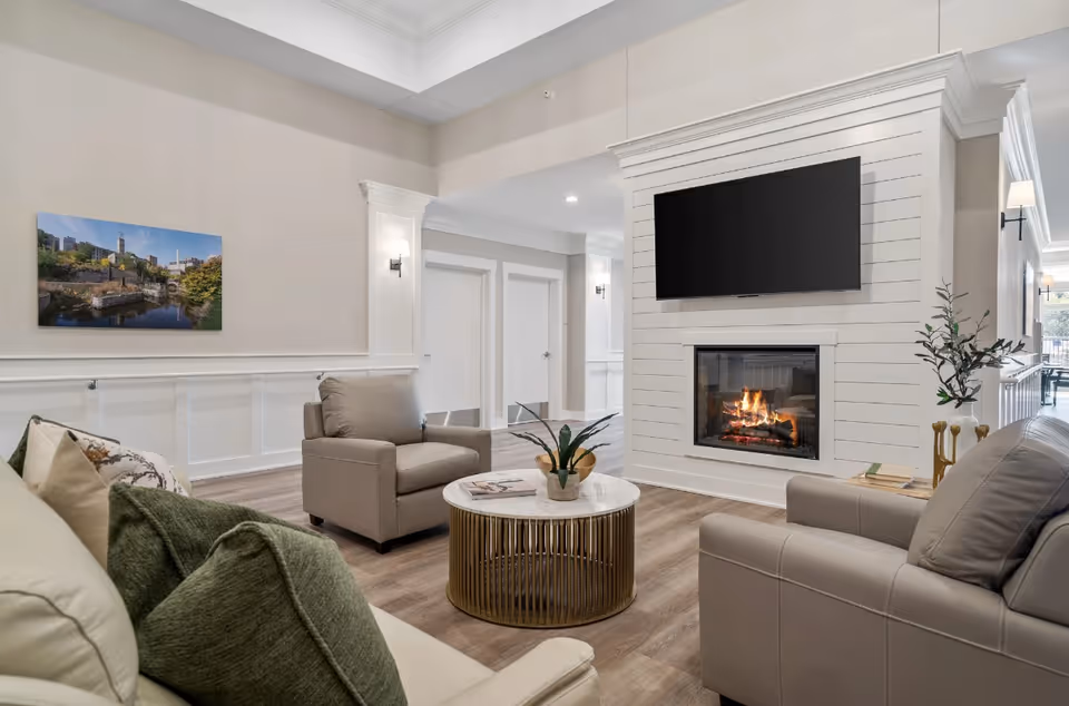 Bright, modern living room with fireplace, wall-mounted TV, and comfortable seating.