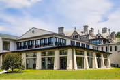 Beaumont At Bryn Mawr exterior: modern building with glass, columns, and manicured lawn.