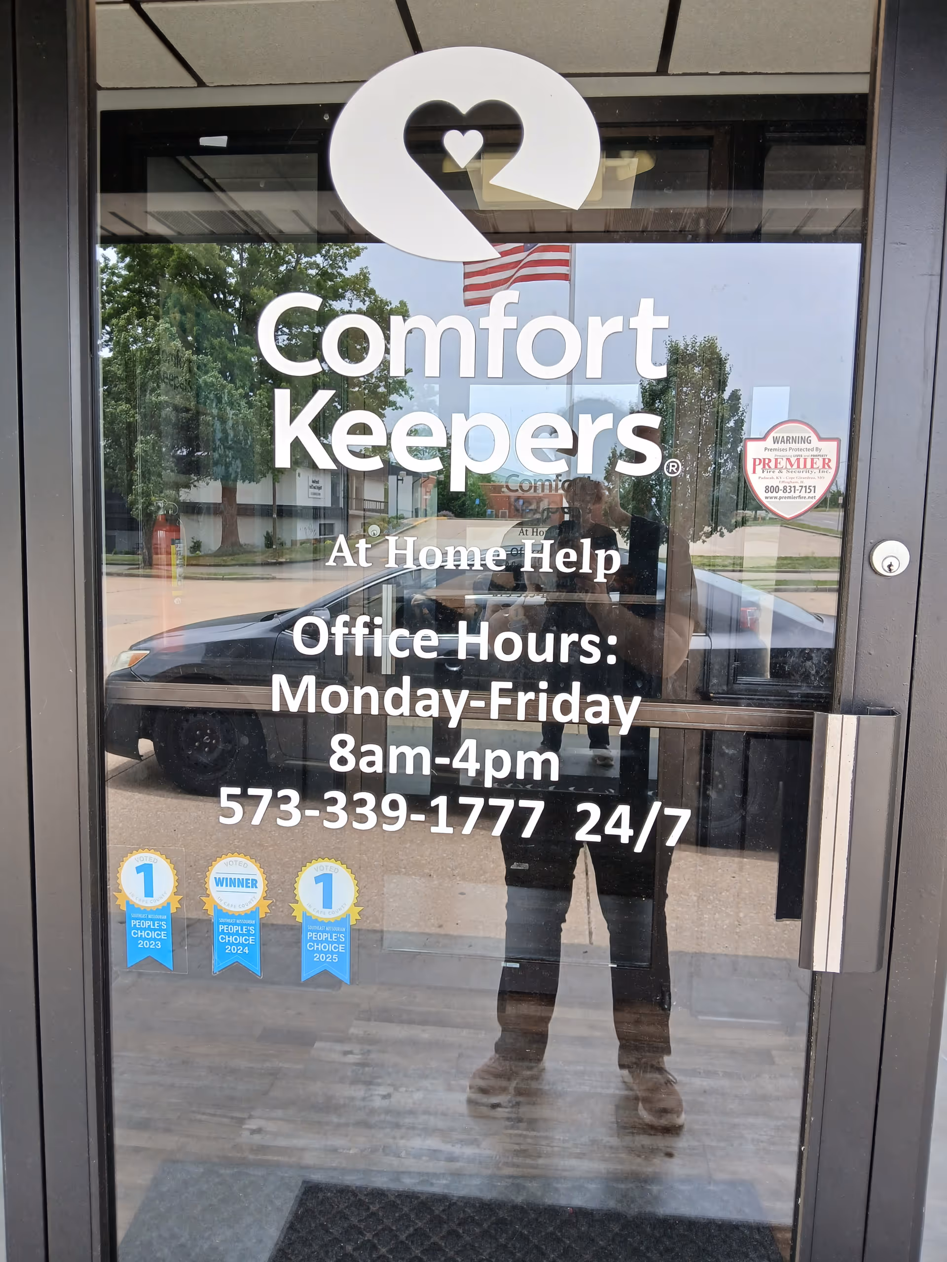 Glass door featuring Comfort Keepers Home Care branding and office hours sign.
