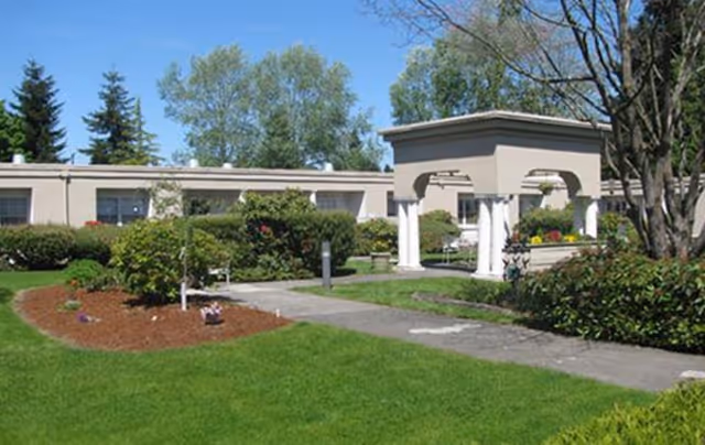 Exterior view of Snohomish Health and Rehabilitation with green lawn and walkway.