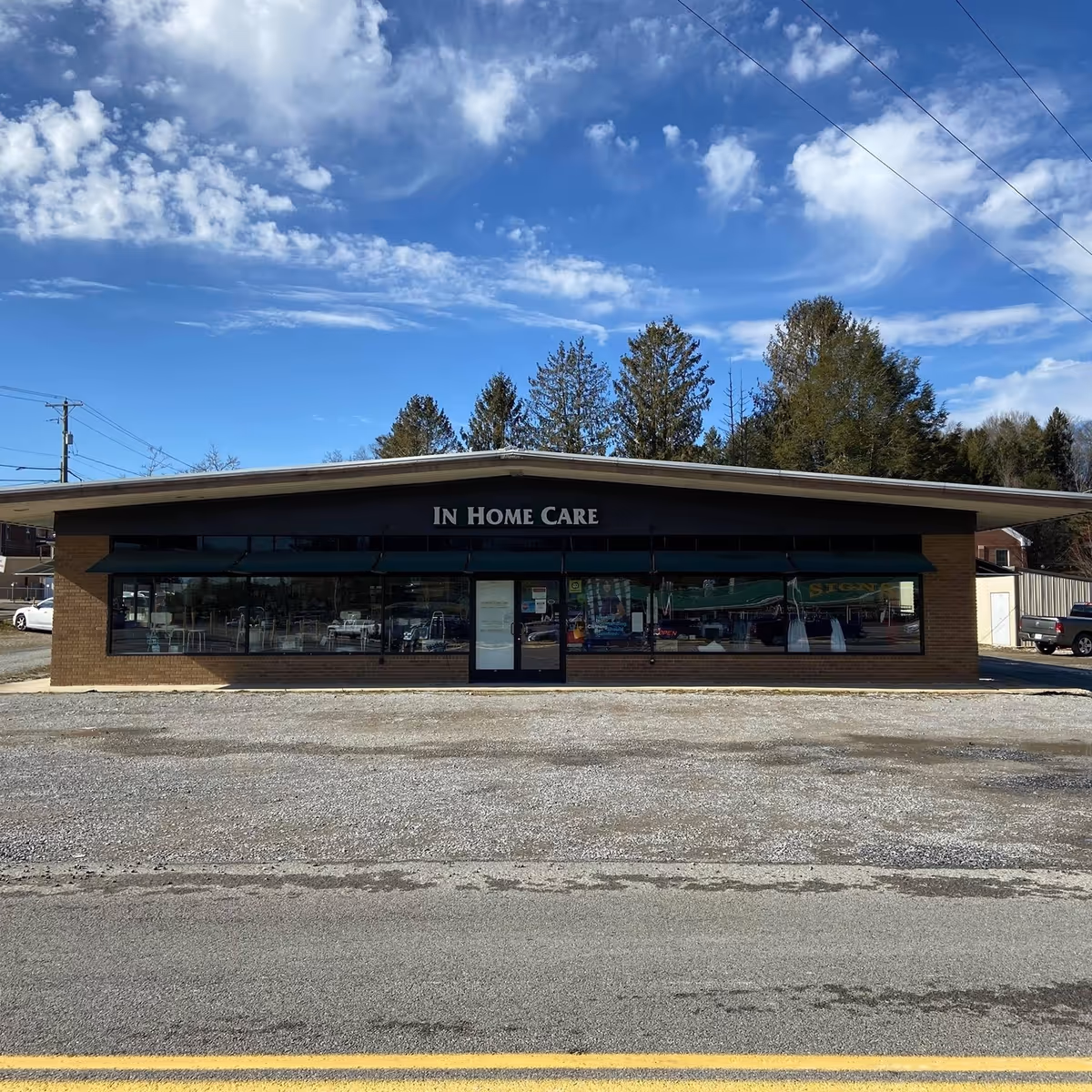 A single-story brick storefront with large windows and an In Home Care sign.