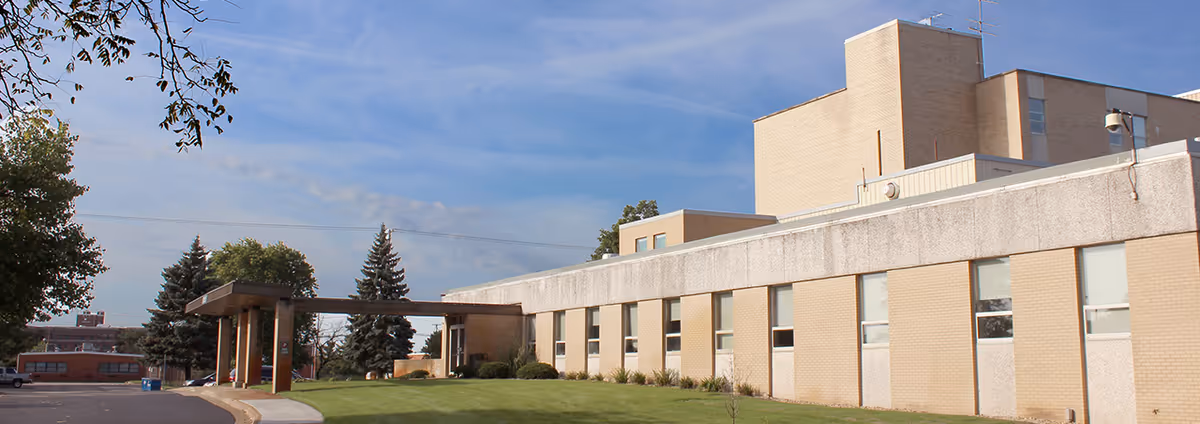 Exterior view of Bronson at Home facility with beige brick walls and a covered entrance.
