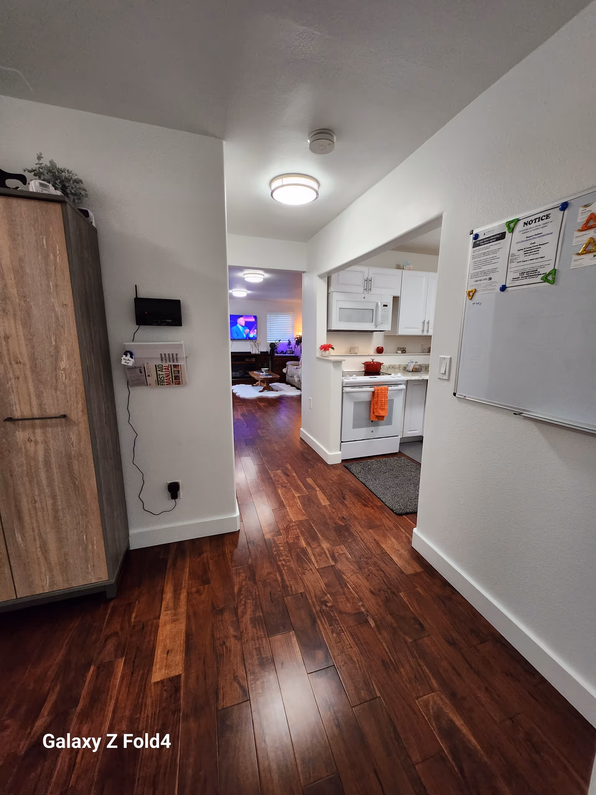 Hallway in a senior living facility with a visible kitchen on the right.