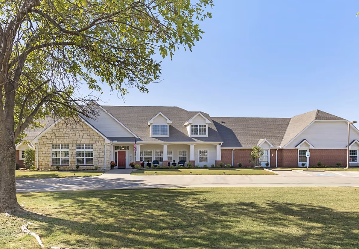 Front exterior view of Brookdale Richland Hills with lawn and tree in foreground.