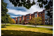Exterior view of The Village at St. Barnabas building with green lawn and trees.