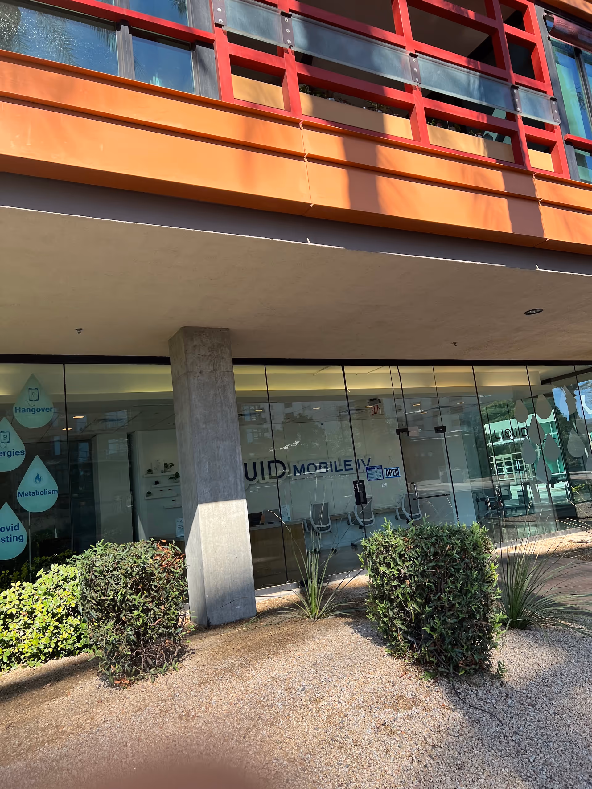 Exterior storefront of Liquid Mobile IV clinic with glass doors and colorful facade.