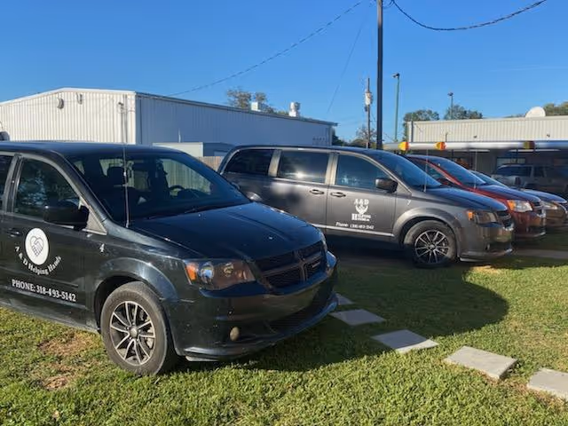 Exterior view of A and D Helping Hands with several company vans parked in a lot.
