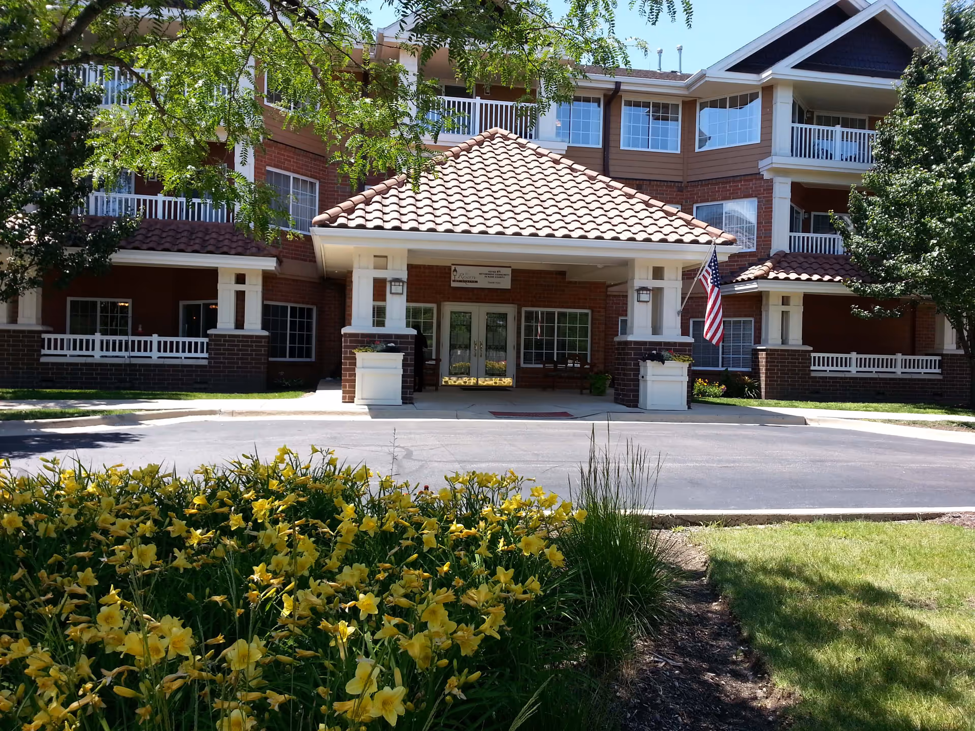 Front view of The Reserve of Geneva senior living entrance with brick facade and landscaping.