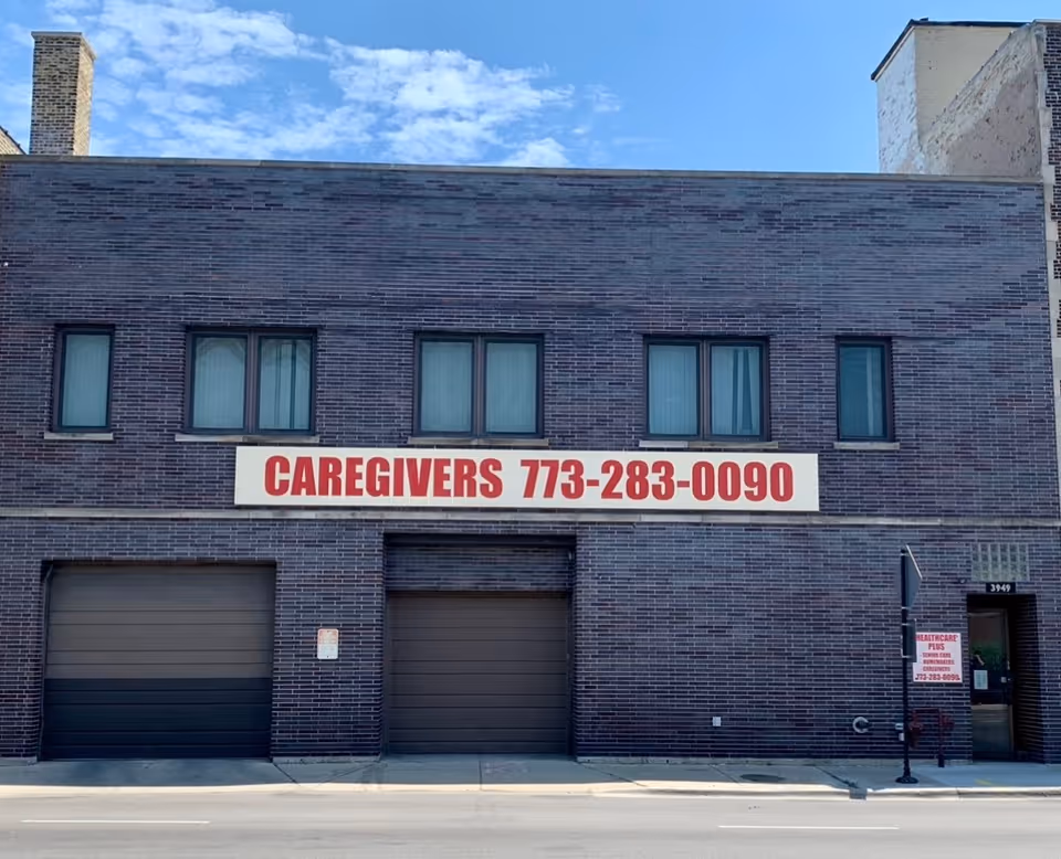 Brick building exterior with a large 'Caregivers' sign and three upper windows.