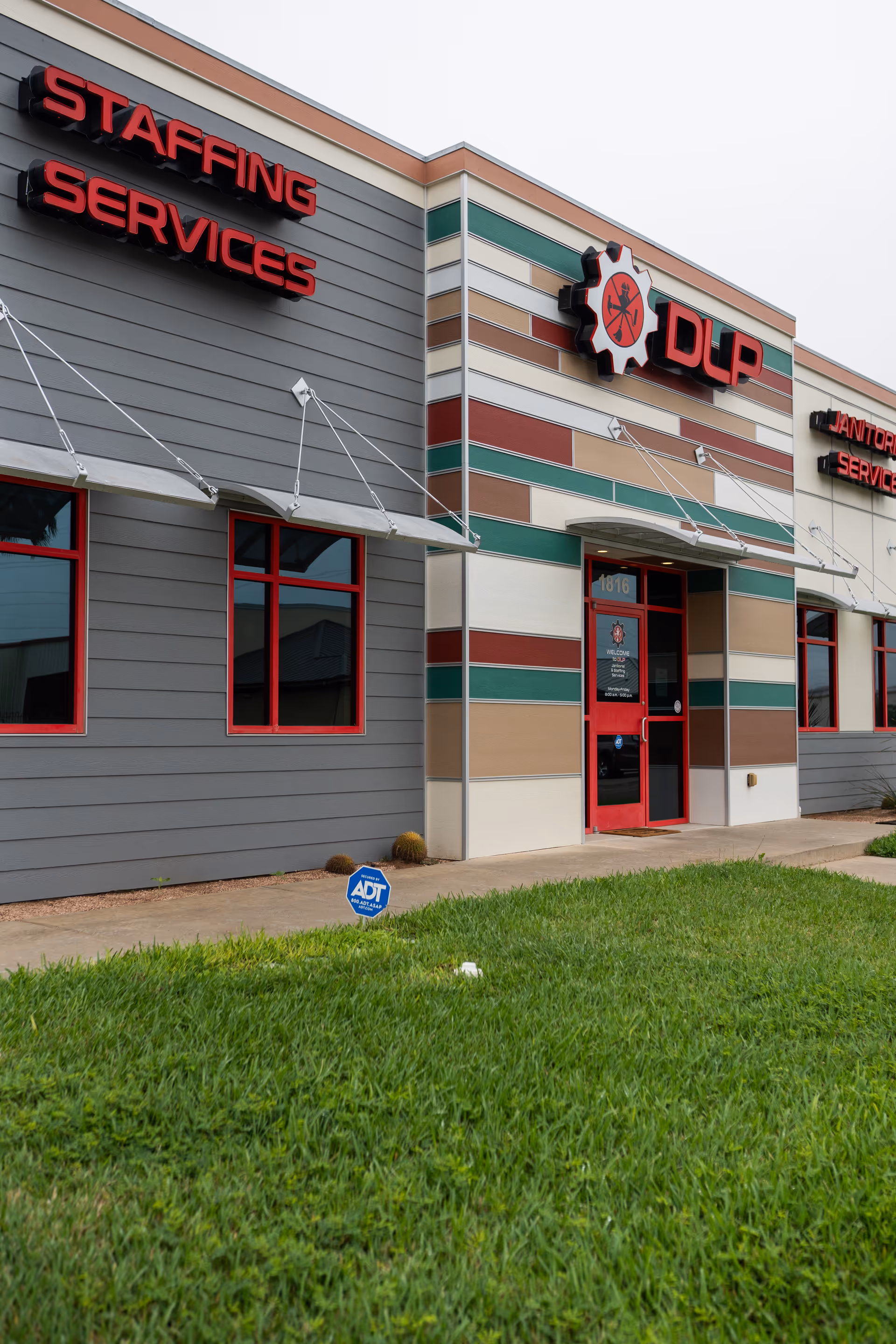 Exterior view of a DLP Services LLC building with colorful striped facade and front entrance.