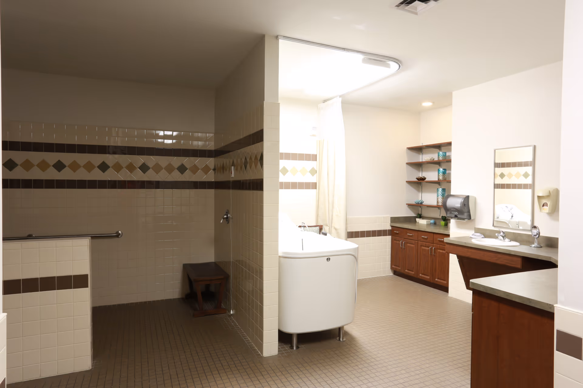 Spacious accessible bathroom with tiled walk-in shower, bathtub with curtain, sink and wooden cabinets.