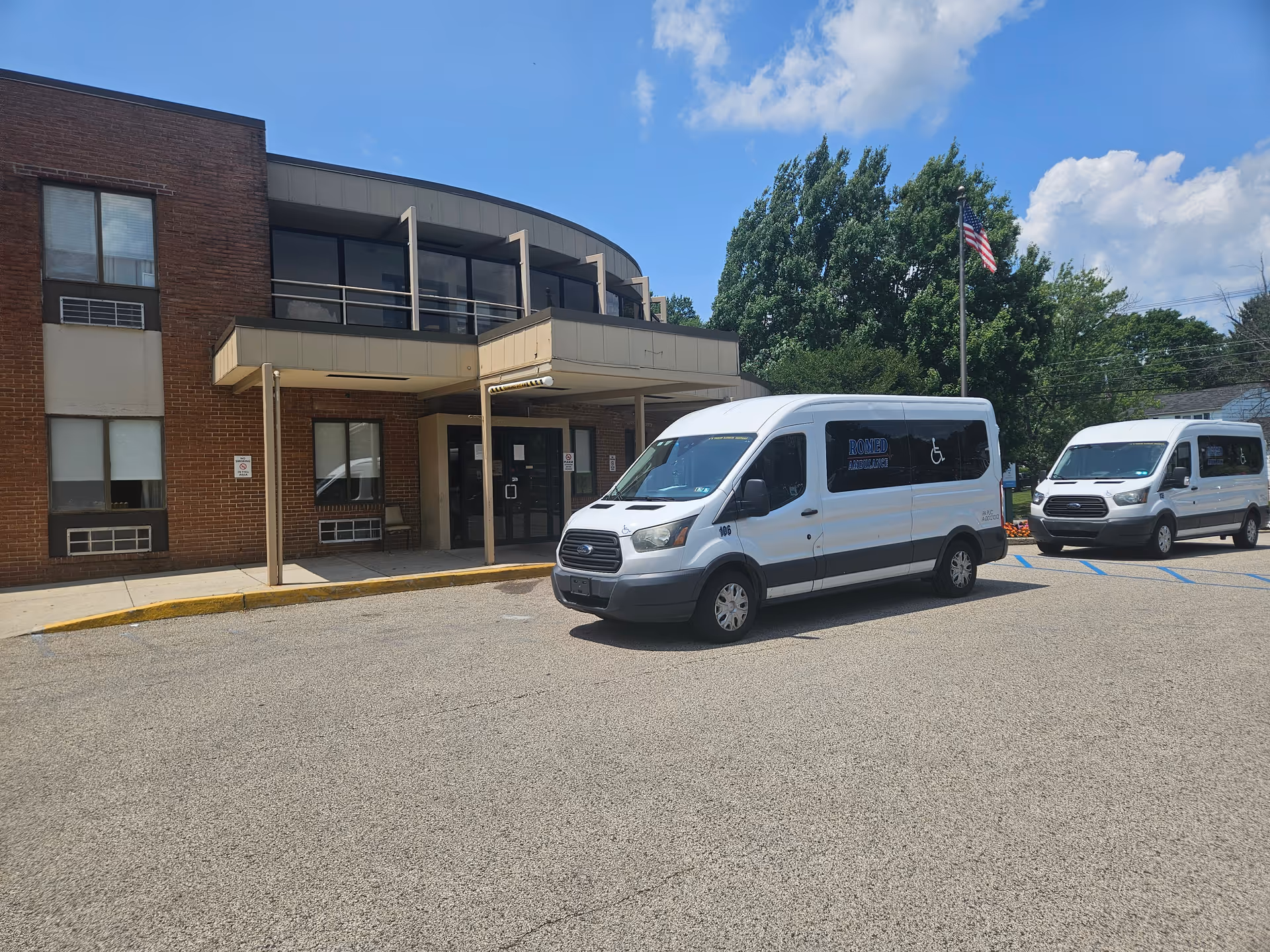 Towne Manor East front exterior with two white vans in the parking lot