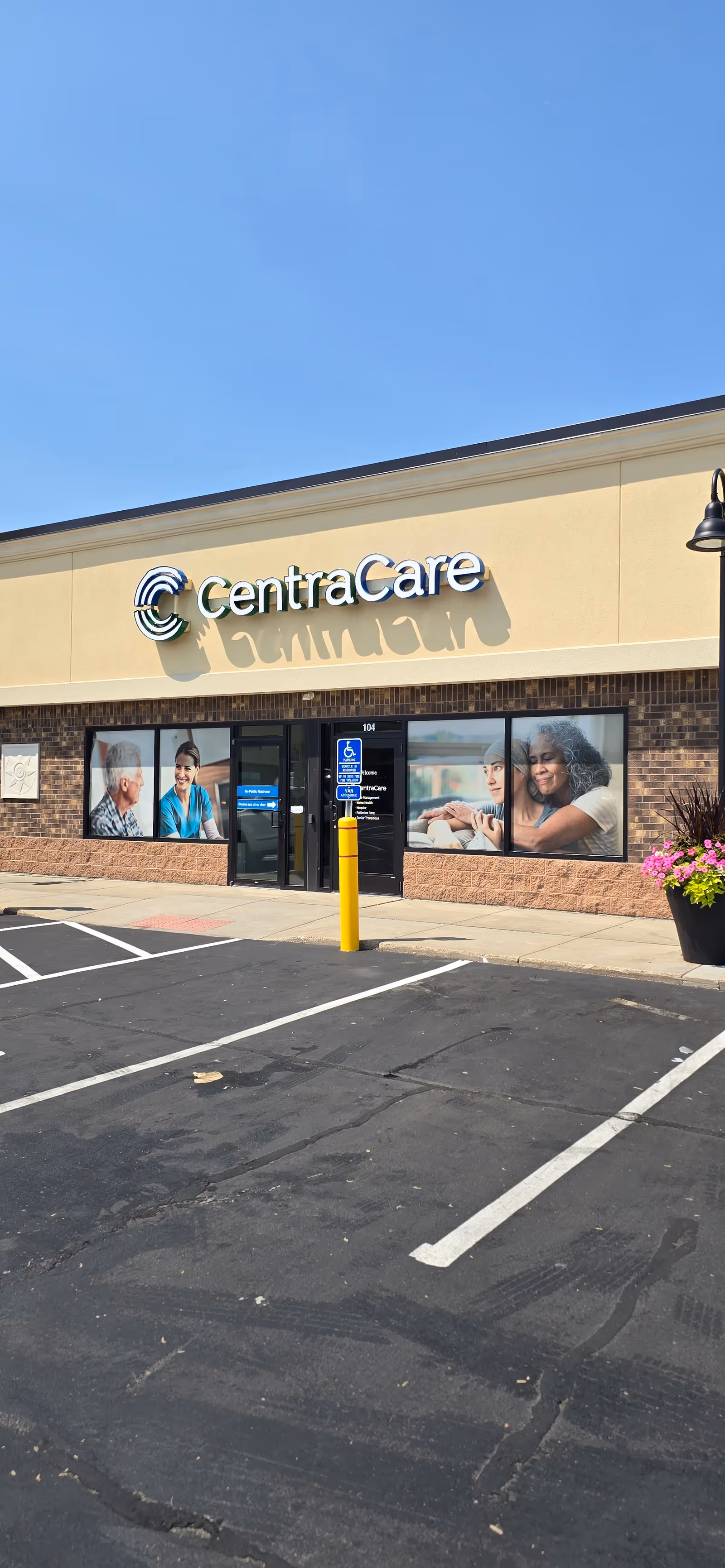 CentraCare storefront exterior with sign, windows showing photos, and a parking lot.
