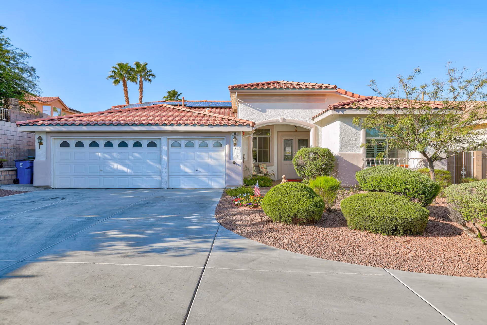 Front view of a single-story home with a two-car garage and landscaped yard.