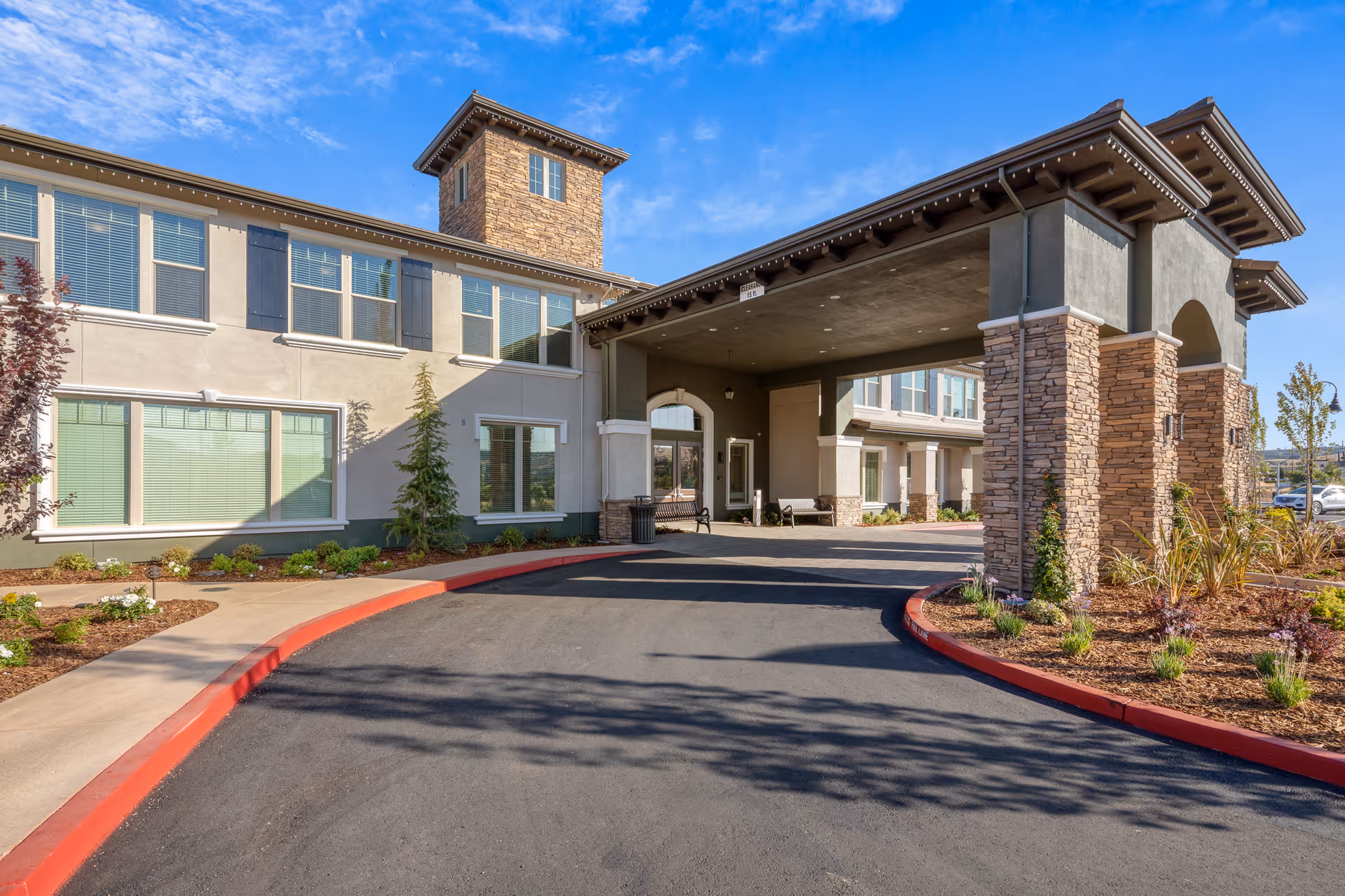 Exterior view of Oakmont of El Dorado Hills with a covered driveway and stone columns.