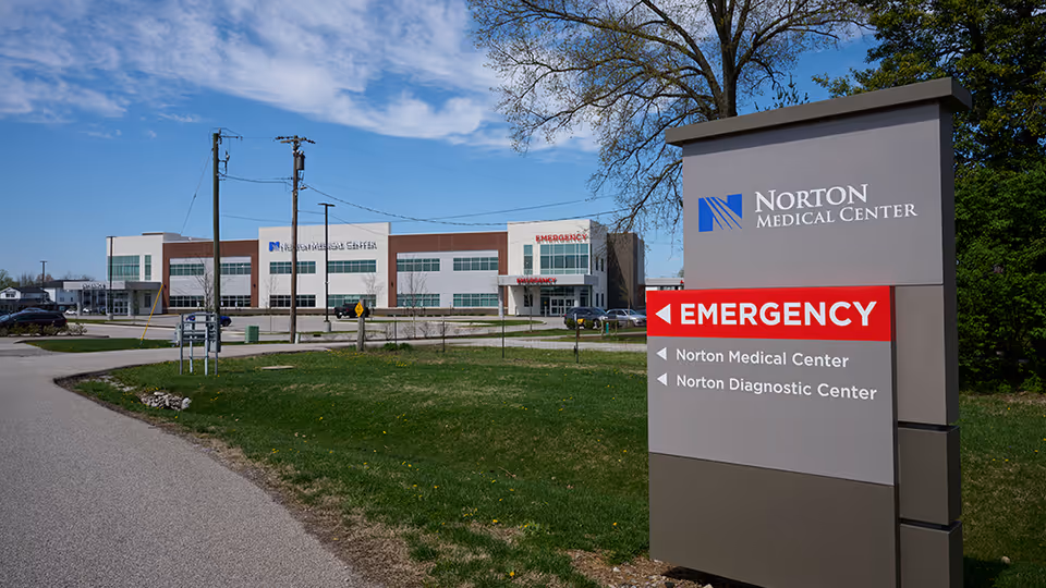 Exterior view of Norton Medical Center with large front sign and Emergency entrance in background.