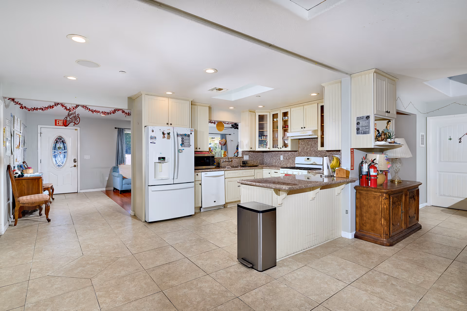 Bright open kitchen in Oceanside Elderly Care Home with white cabinets and central island.