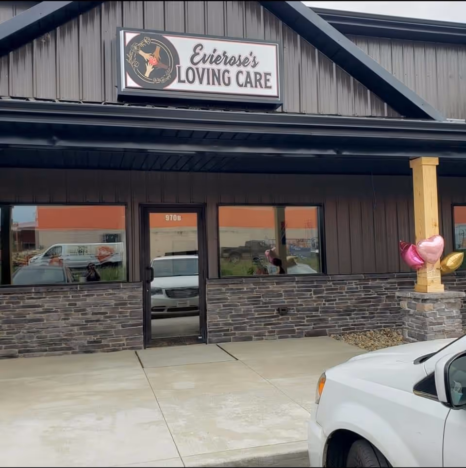 Front exterior of a dark brown building with Evierose's Loving Care sign and balloons.