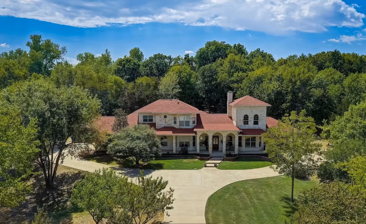 Aerial view of a red-roofed assisted living facility surrounded by trees.