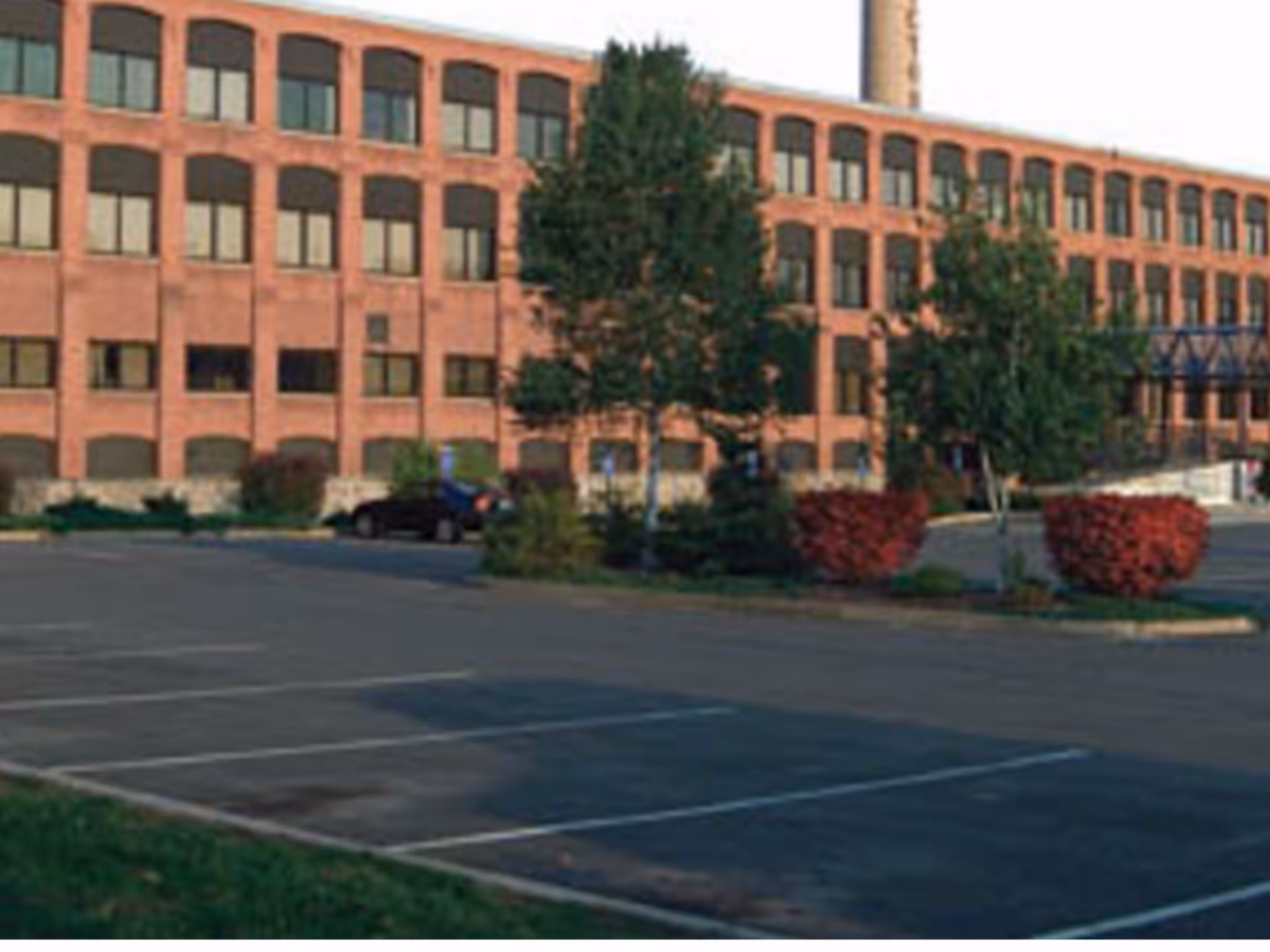 Exterior view of a brick nursing facility with a parking lot and landscaping.