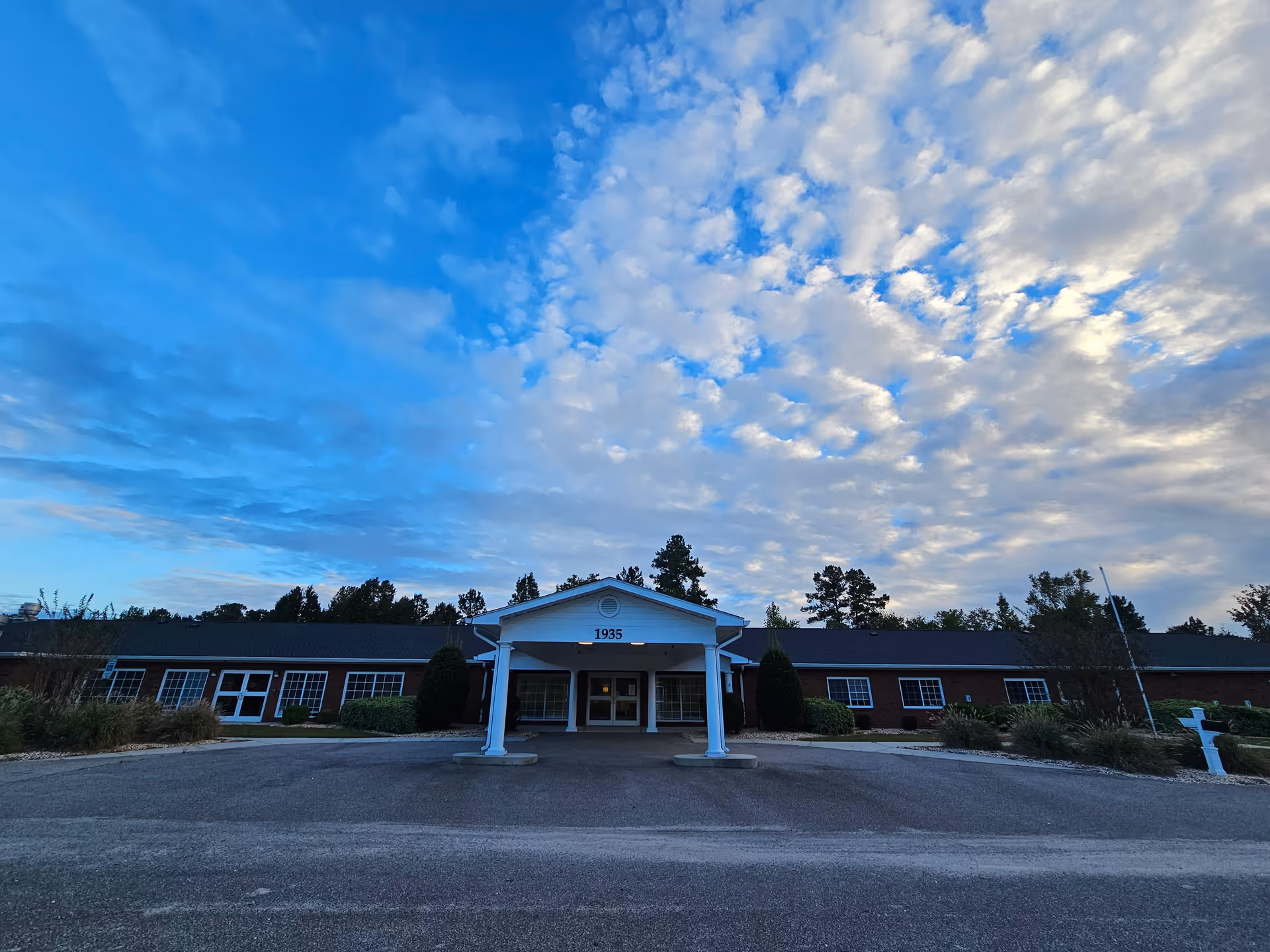 Exterior view of Leland House senior living facility entrance with a covered portico.
