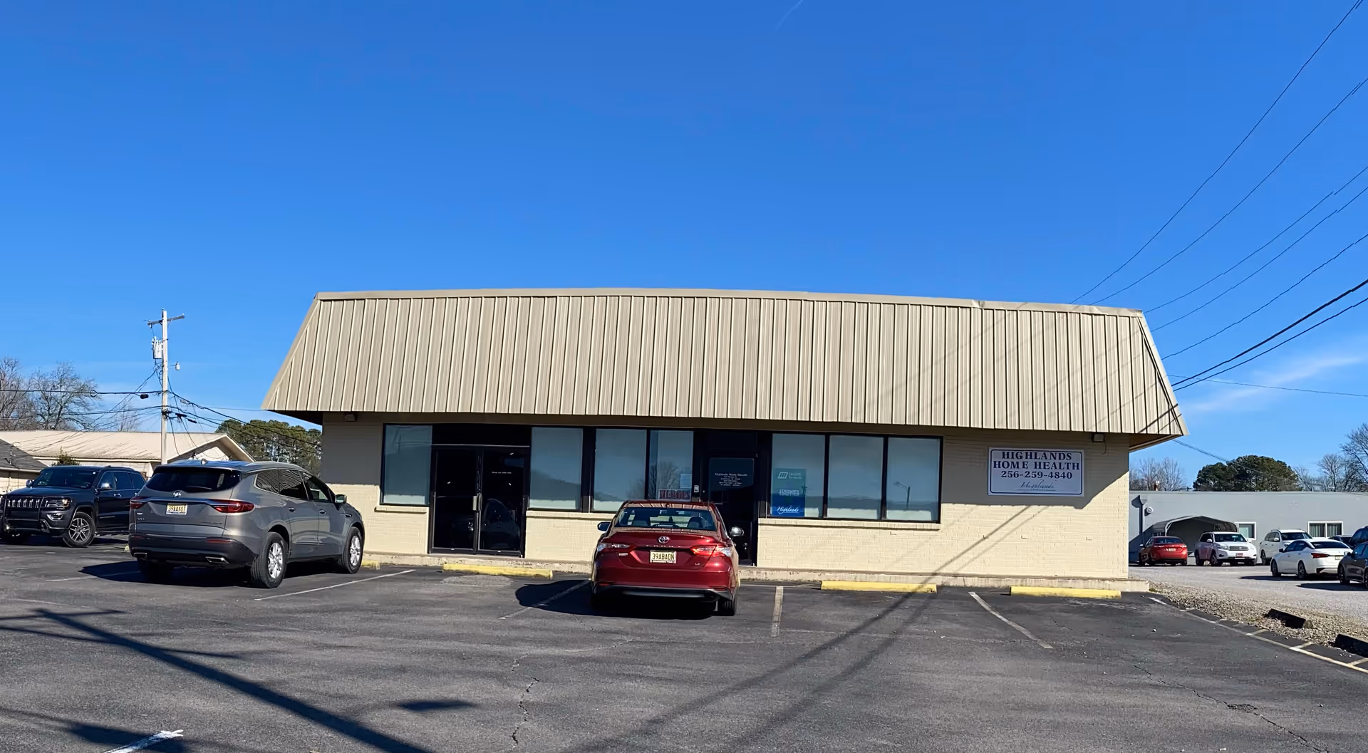 Exterior view of Highlands Home Health building with a parking lot and clear blue sky.
