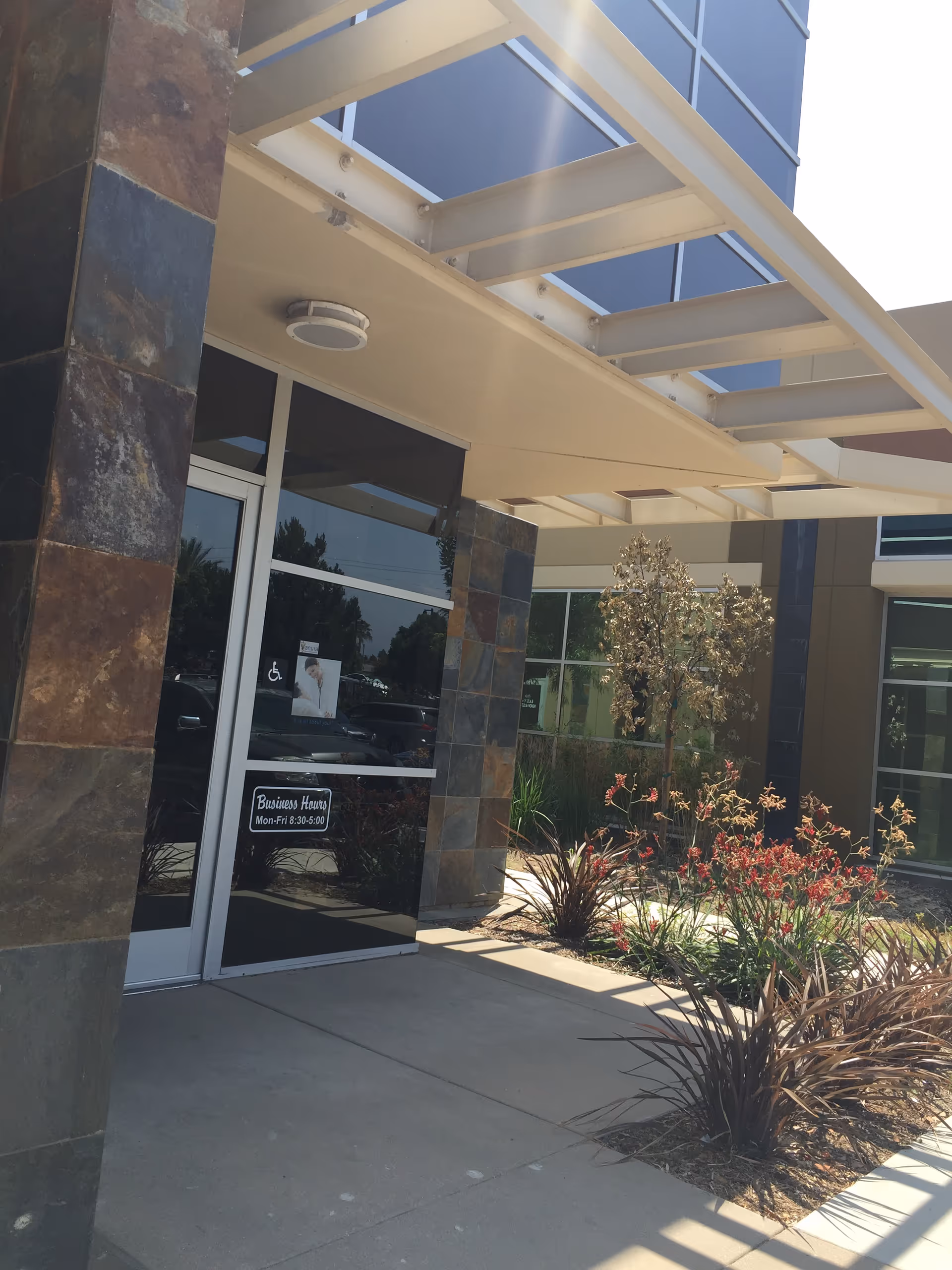 Exterior entrance of Vanura Home Health Services with glass doors and landscaping.