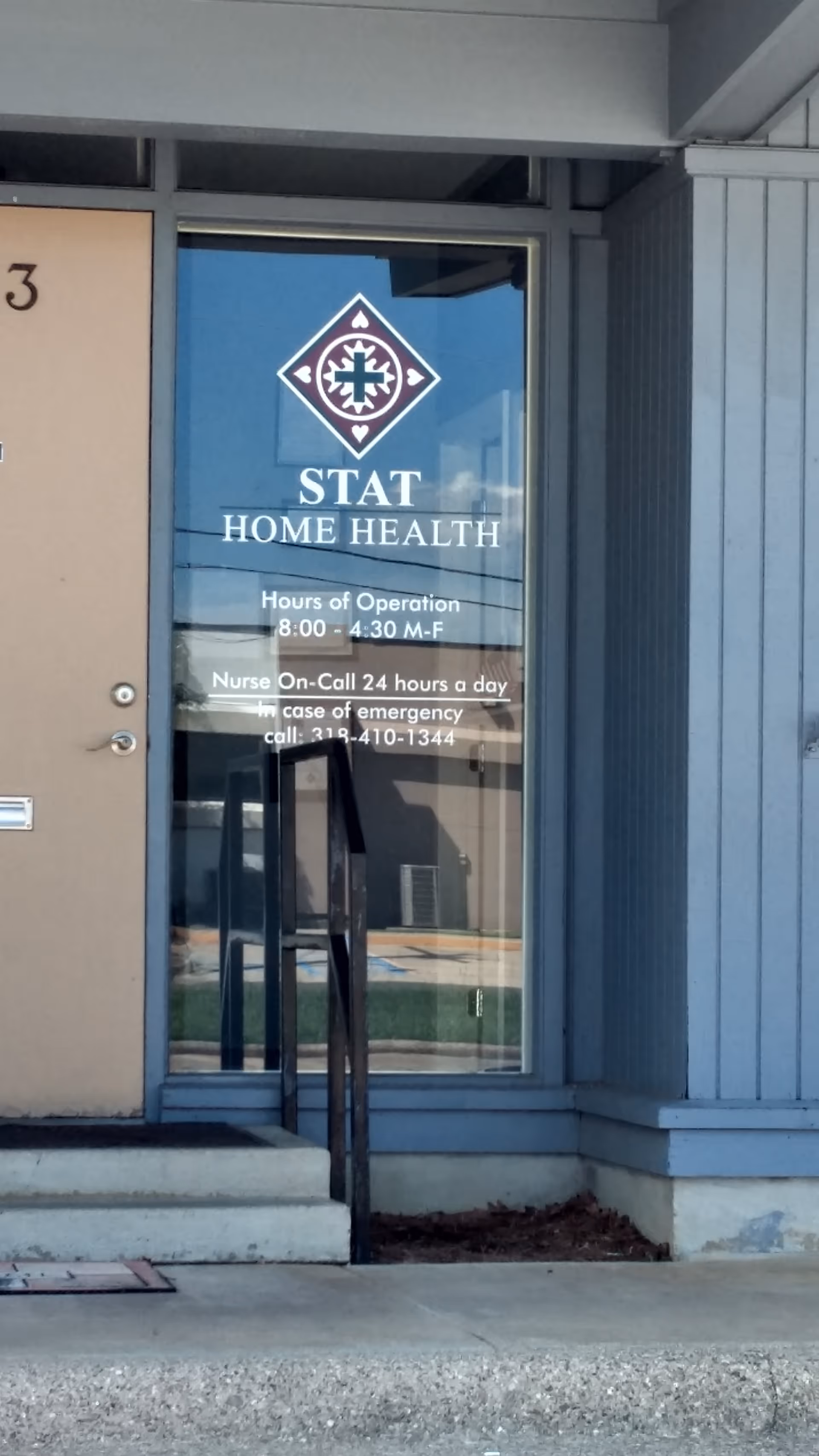 Front entrance of STAT Home Health building with glass door and logo.