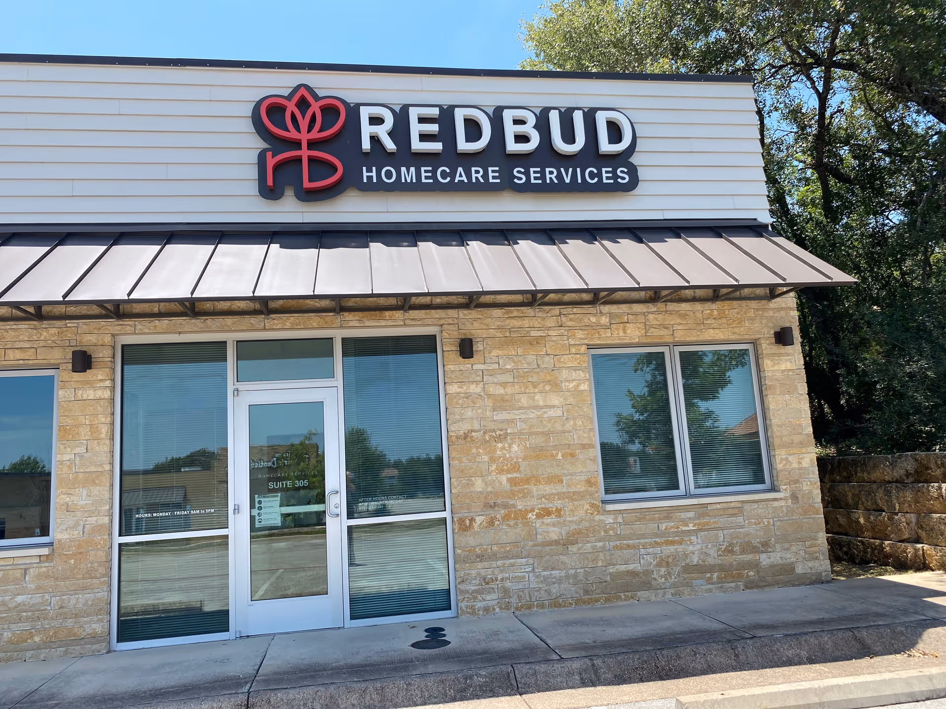 Exterior view of a stone-front clinic building with a large Redbud Homecare Services sign
