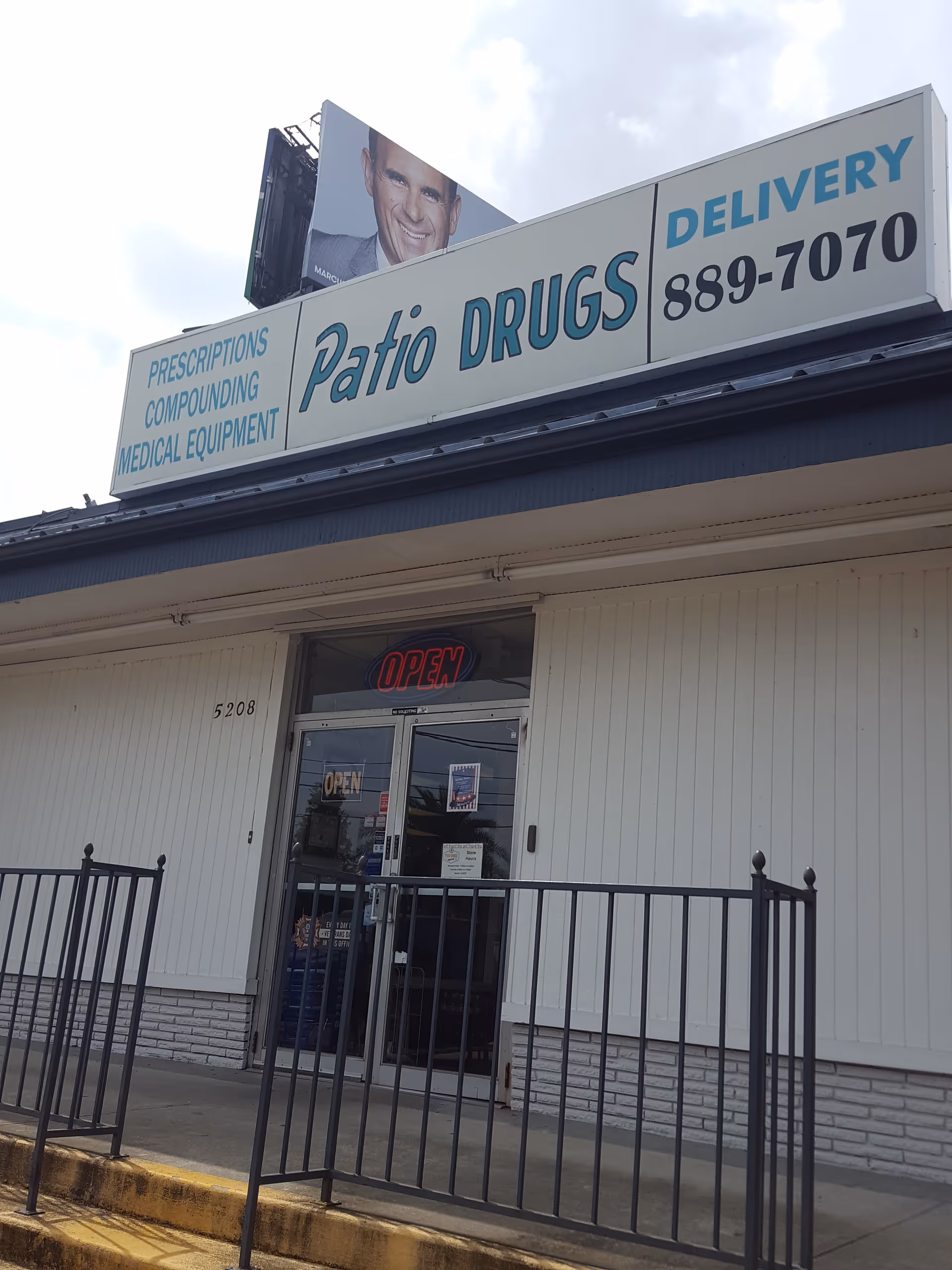 Exterior storefront with Patio Drugs sign and open glass doors.