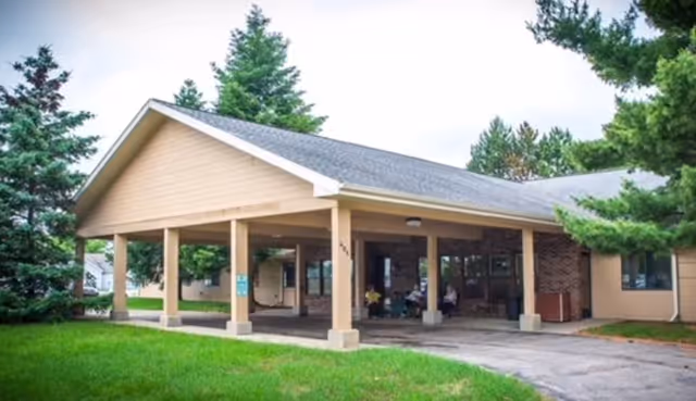 Stanford Lodge senior living facility entrance with a covered porch and green lawn.
