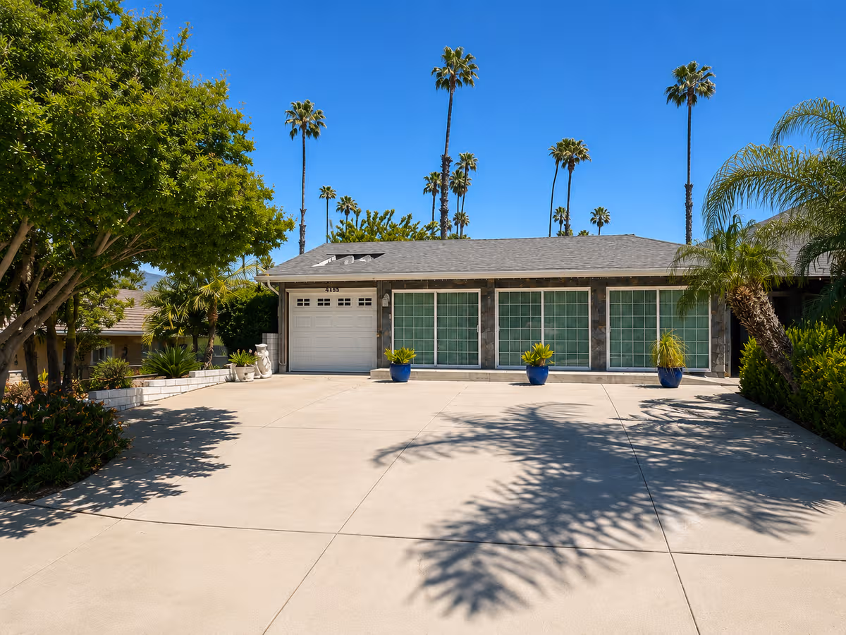 Front view of Rosemont Villa senior living facility with large windows and palm trees.