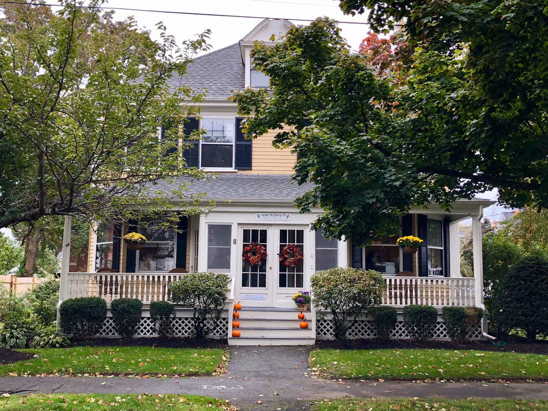 Front view of Aberdeen Home Care, Inc. building with a porch and pumpkins.
