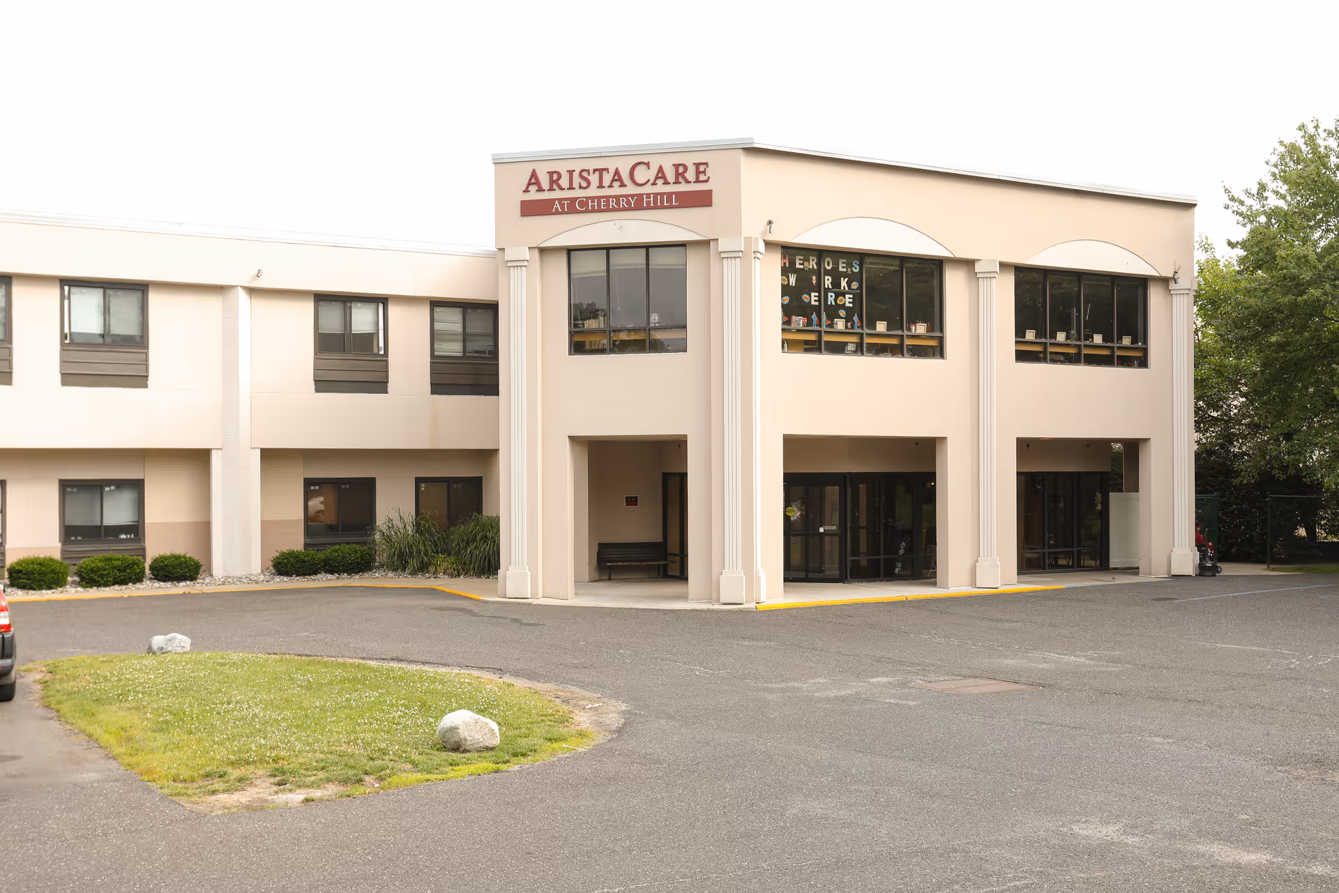 Exterior view of AristaCare at Cherry Hill showing the entrance and parking lot.