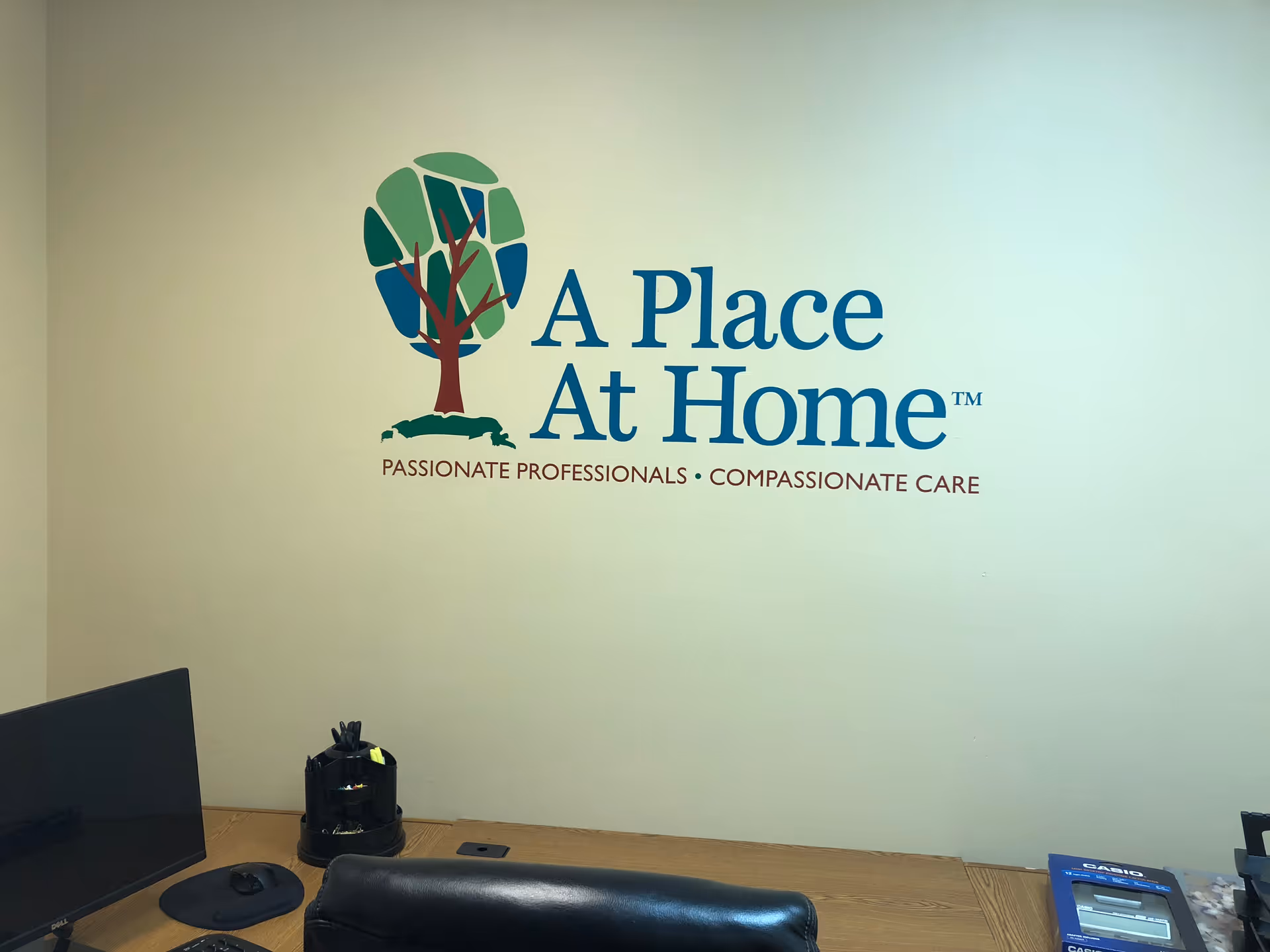 Interior office wall with A Place At Home logo and desk supplies